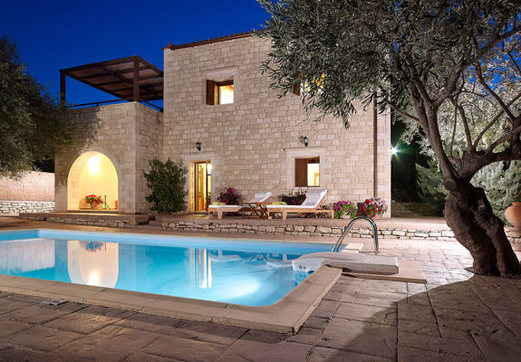 Vederi Estate Villa Kyveli pool and villa exterior lit up at dusk