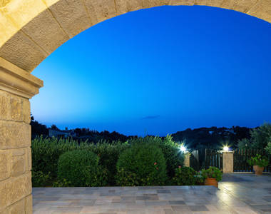 Vederi Estate Villa Melpomeni view of the lit up garden at dusk
