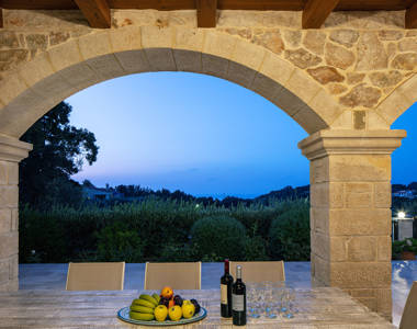 Vederi Estate Villa Melpomeni view from the outdoor table at dusk