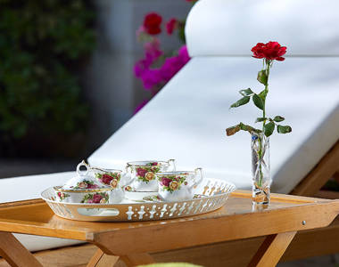 Vederi Estate Villa Kyveli sunbed table with a tray full of teacups and a flower next to it