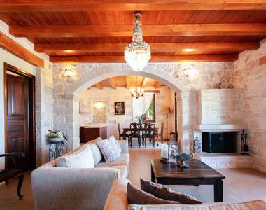 Vederi Estate Villa Melpomeni living room with fireplace and kitchen view